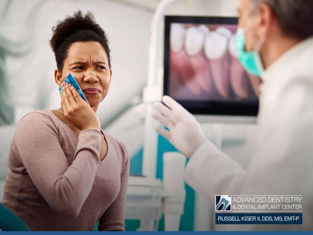 Patient experiencing discomfort, possibly due to Root Canals reinfected, while discussing treatment with a dentist