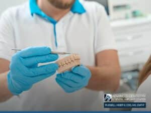 Dentist explaining Bone Grafting with a dental model