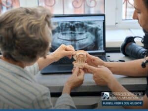 Dentist explaining All-on-4 dental implants to a patient during consultation