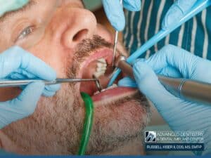 Dentist performing mouth reconstruction treatment on a male patient