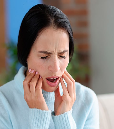 woman-with-severe-acute-tooth Woman experiencing severe tooth pain requiring emergency dental care